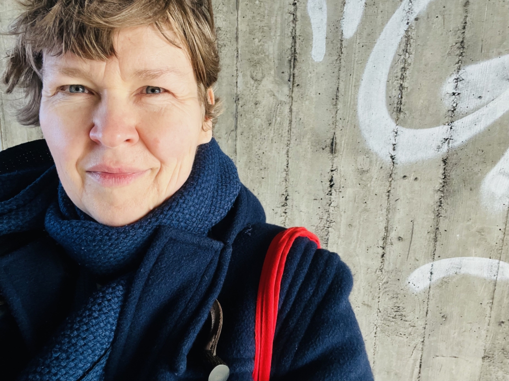 portrait sandy craus vor betonhintergrund mit weißem grafitti